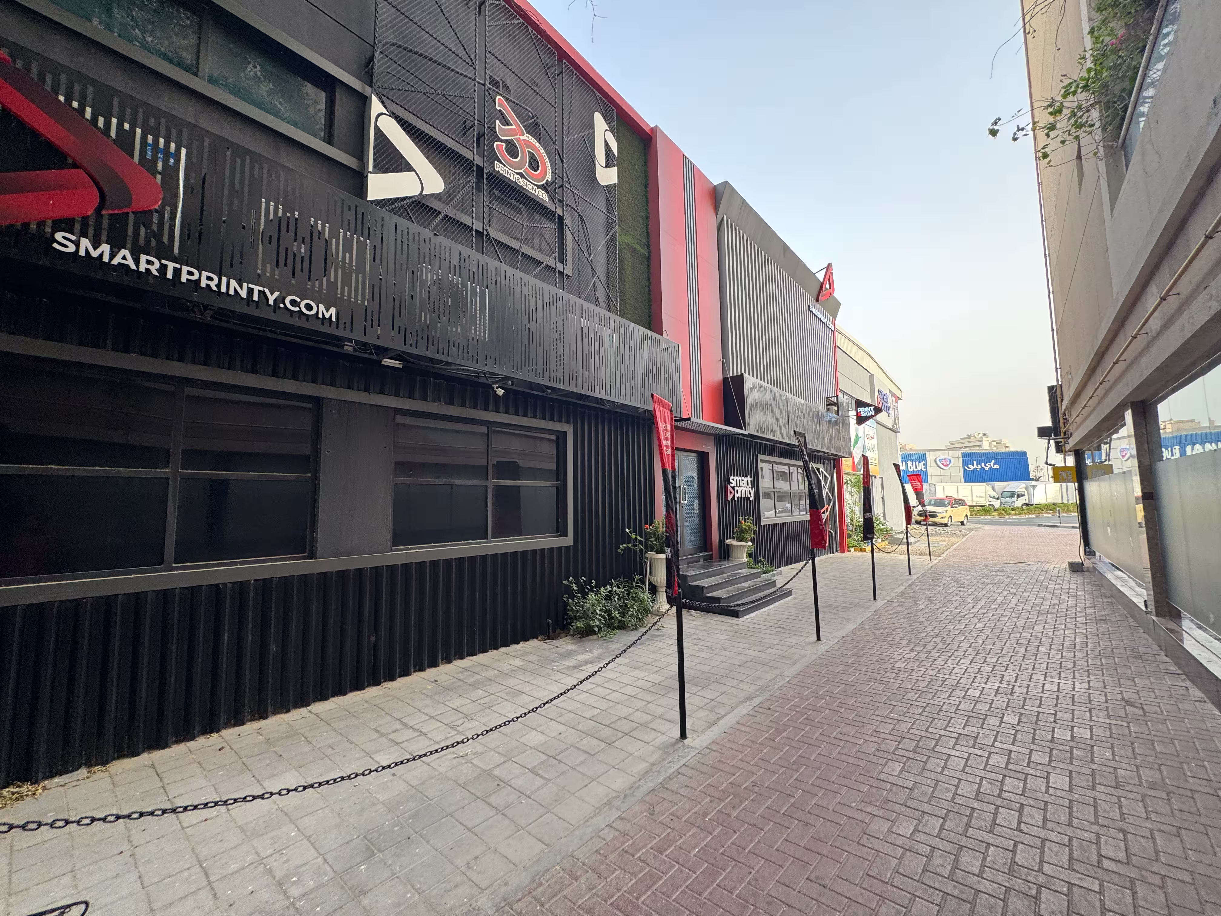 Exterior of a two-story commercial printing building with signage and outdoor branding displays