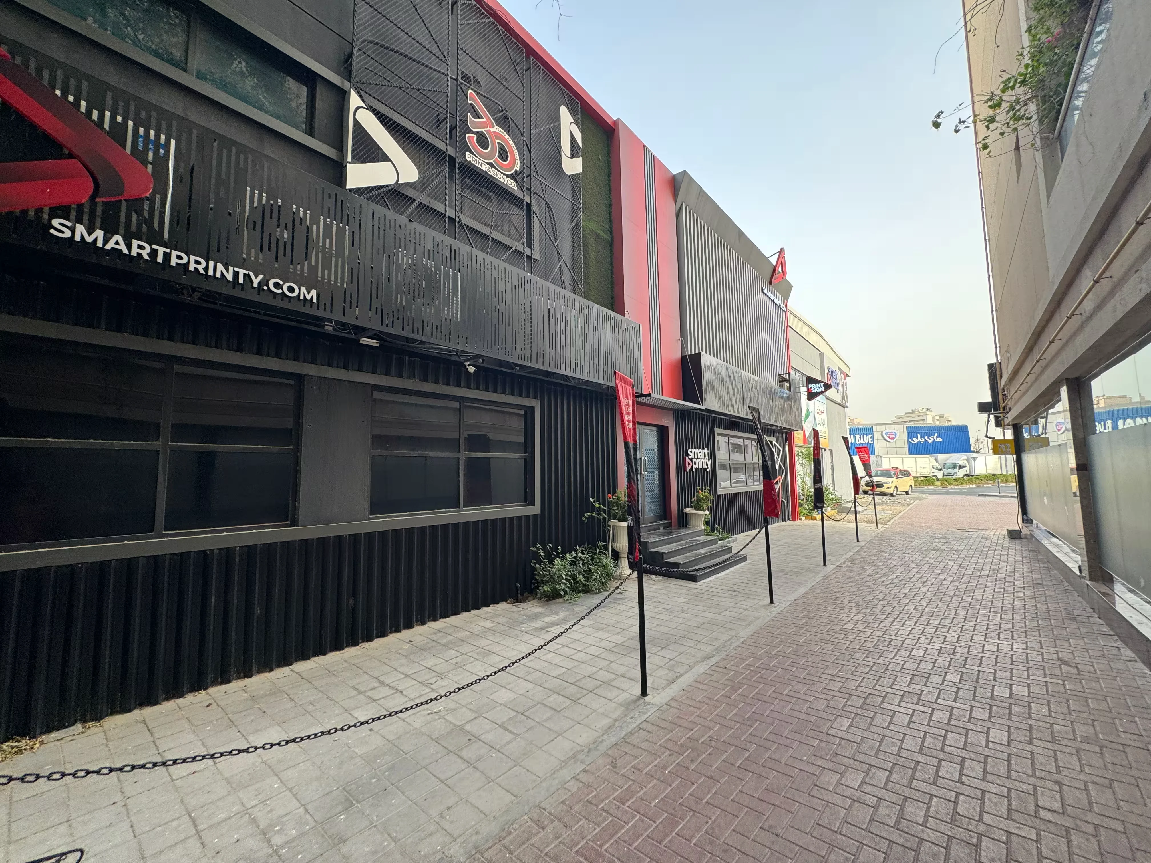 Exterior of a two-story commercial printing building with signage and outdoor branding displays