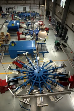 Start producing in-house. Industrial multi-arm screen printing carousel on the factory floor
